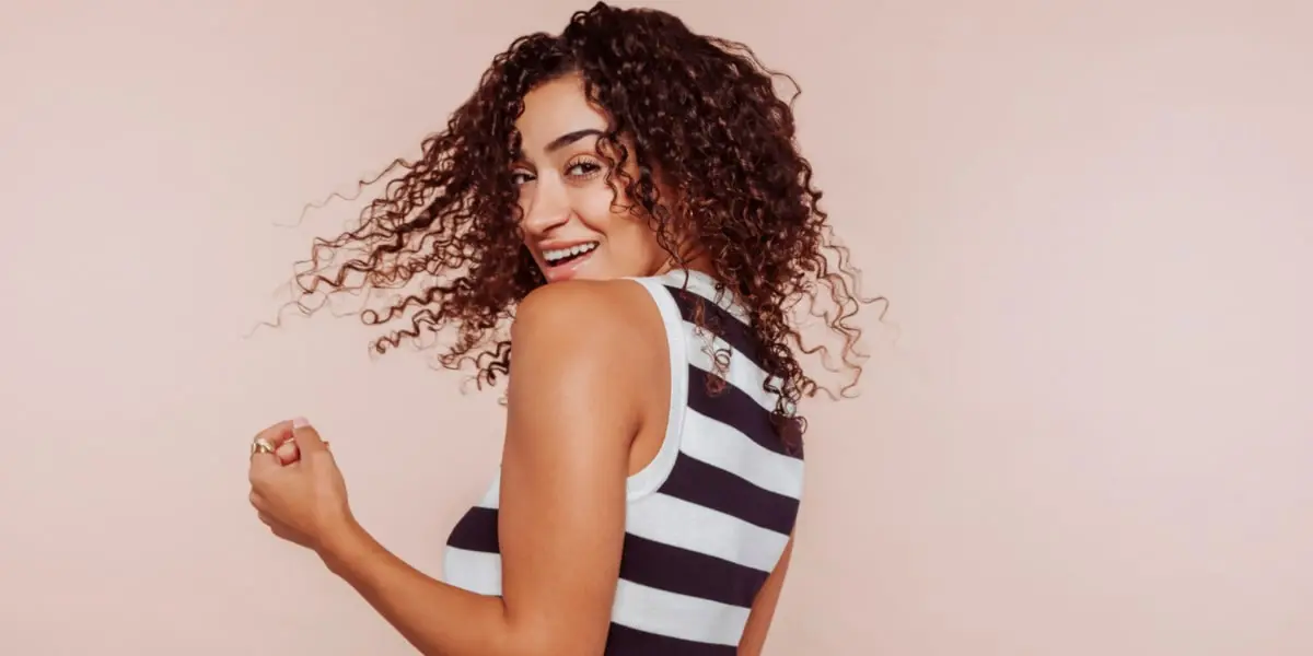 Mujer con pelo rizado sonriendo Mujer con pelo rizado sonriendo