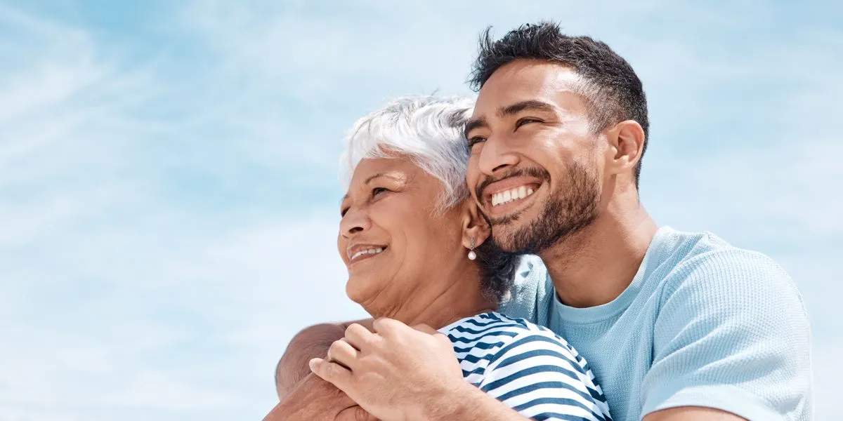 Mutter und Sohn blicken lächelnd auf den Horizont
