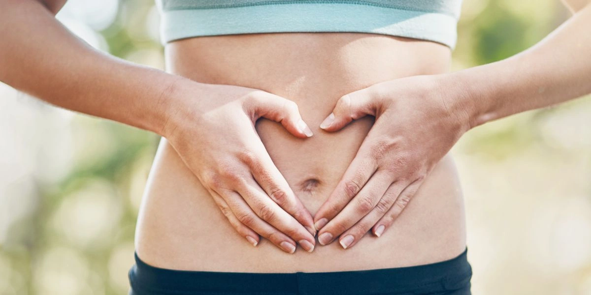 Frau berührt ihren Bauch, erleichtert nach Bauchschmerzen