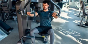 Wie man die Brustpresse an der Maschine im Sitzen richtig ausführt