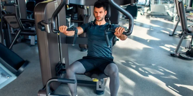 Wie man die Brustpresse an der Maschine im Sitzen richtig ausführt Wie man die Brustpresse an der Maschine im Sitzen richtig ausführt